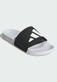 Black and white slide sandal with a wide, textured strap featuring white geometric accents and a soft white footbed for comfort.