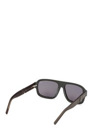 Obdélníkové sluneční brýle s tmavými skly. Rám z matného černého plastu s hnědými detaily na spáncích. Hladký povrch, žádné viditelné vzory.