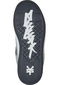 Semelle en caoutchouc noire avec des motifs de grip texturés ; présente un logo et des accents blancs ; bord supérieur lisse en gris ; design épuré.