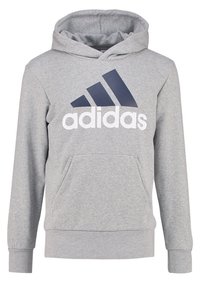 Sweat à capuche gris en tissu mélangé coton, avec une poche kangourou à l'avant, des poignets côtelés, et un grand logo Adidas bleu marine sur la poitrine.
