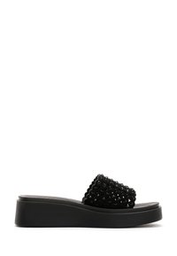 Sandali platform neri con una cintura intrecciata e testurizzata, decorati con piccole perline. Bordo arrotondato e suola liscia e opaca.