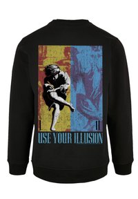 Black sweatshirt featuring a graphic print on the back with a person in motion amidst bold yellow, blue, and red sections, with text "USE YOUR ILLUSION."