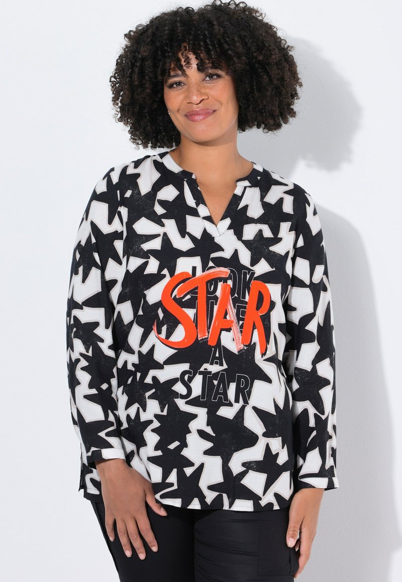 Zwart-witte blouse met lange mouwen met een sterrenpatroon en een oranje grafische tekst "Kijk een ster." V-hals ontwerp, relaxte pasvorm.