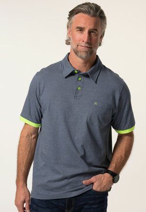 Polo à rayures navy avec des manches courtes, des accents vert citron sur les manches et le col, et une poche poitrine. Fabriqué à partir d'un matériau doux et texturé.