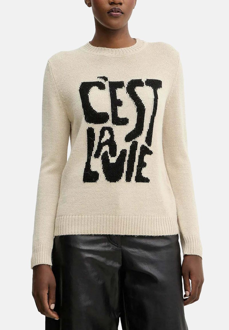 Maglione a maglia color crema con una grafica nera che riporta il testo "C'est la vie." Collo a giro classico e polsini e orlo a coste.