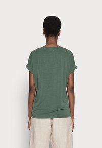 Green, short-sleeved t-shirt with a round neck and rolled cuffs. Made of soft fabric, features a relaxed fit and a smooth texture.
