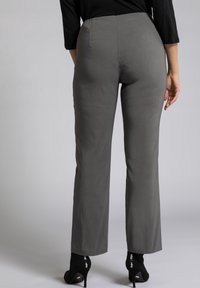 Grijze broek met een rechte pijpdesign, met een gladde textuur en een hoge tailleband. Gecombineerd met zwarte enkellaarsjes met hoge hakken.