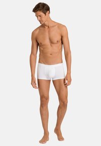 White boxer briefs with a snug fit featuring a soft waistband and smooth texture. The design offers minimal coverage and a classic shape.
