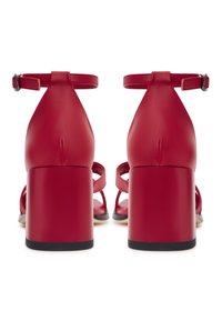 Rode leren hoge hak sandalen met een blokhak, enkelbandje en open neus ontwerp. Gladde oppervlakte met minimale hardware details.