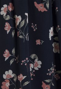 Tela floral en azul marino, con flores rosas y blancas acompañadas de hojas verdes. La textura parece suave y ligeramente translúcida con un patrón delicado.