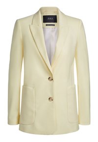 Vaaleankeltainen bleiseri, joka on valmistettu sileästä kankaasta. Siinä on rakenteellinen muotoilu, kaksi etutaskua ja kolme pyöreää nappia edessä.