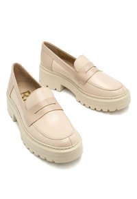 Beżowe skórzane loafersy z okrągłym noskiem, z dwiema poziomymi taśmami z przodu i grubą gumową podeszwą. Gładka tekstura.