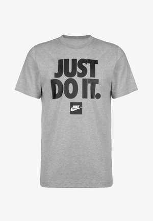 T-shirt en coton gris à manches courtes et col rond. Présente un texte noir audacieux indiquant « JUST DO IT. » et un petit logo Nike.