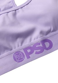 Soutien-gorge de sport violet en tissu doux, avec une large bande élastique portant le logo "PSD". Texture lisse et design de décolleté arrondi pour plus de confort.
