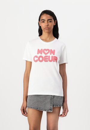 White short-sleeve t-shirt featuring the text "MON COEUR" in bold pink, with a heart accent. Soft, smooth cotton material.
