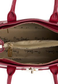 Rode leren handtas met gouden rits, beige stoffen voering bedrukt met "Pierre Cardin," en een binnenzak met rits.
