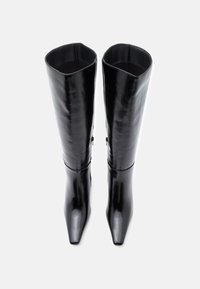 Μαύρες γυαλιστερές δερμάτινες μπότες μέχρι το γόνατο με μυτερή μύτη, λεία υφή και μινιμαλιστικό σχέδιο; διαθέτουν μια διακριτική λεπτομέρεια φερμουάρ στο πλάι.