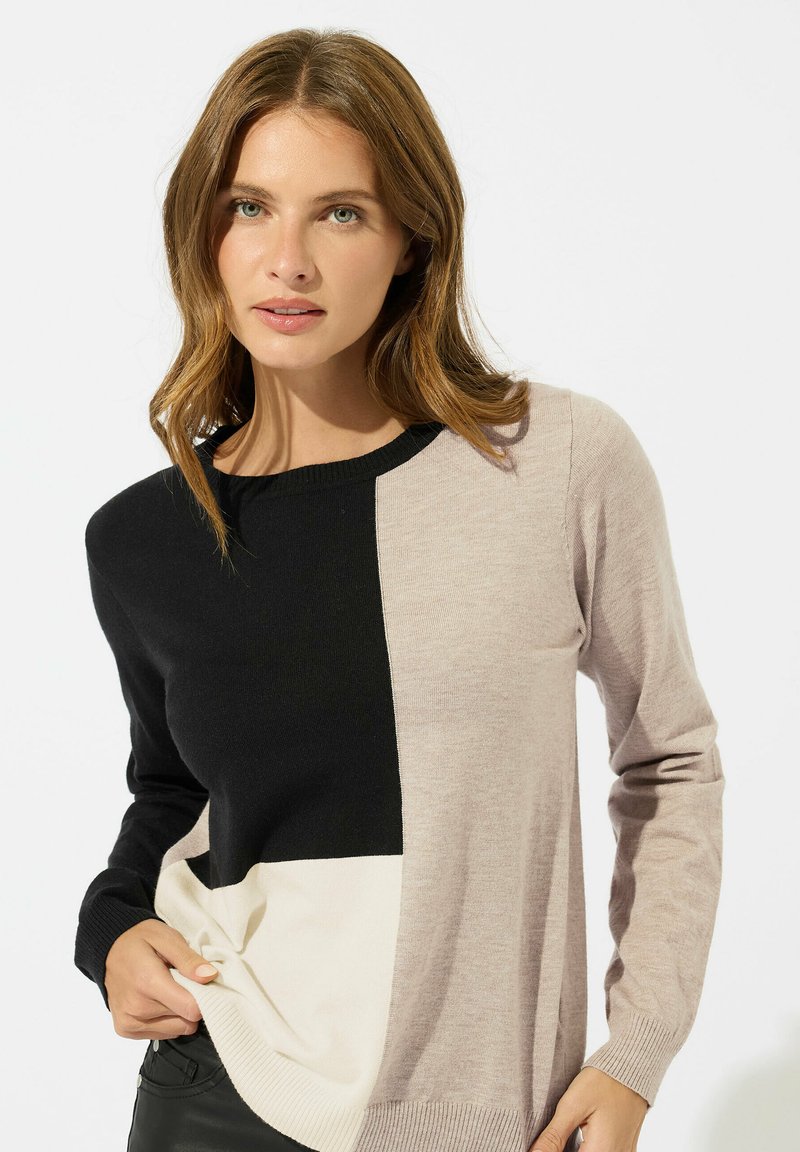 Maglione a maglia con un design a blocchi di colore; presenta sezioni nere, beige chiaro e crema. Collo rotondo, maniche lunghe, polsini a coste.
