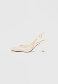 Slingback-stilet med cremefarve, der har spids tå, dekoreret med klare rhinsten og et tekstureret mønster på overdelen.