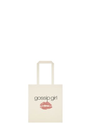 Sac fourre-tout crème avec le texte « gossip girl » au-dessus d’une empreinte de baiser au rouge à lèvres rose, doté de deux anses longueur épaule.