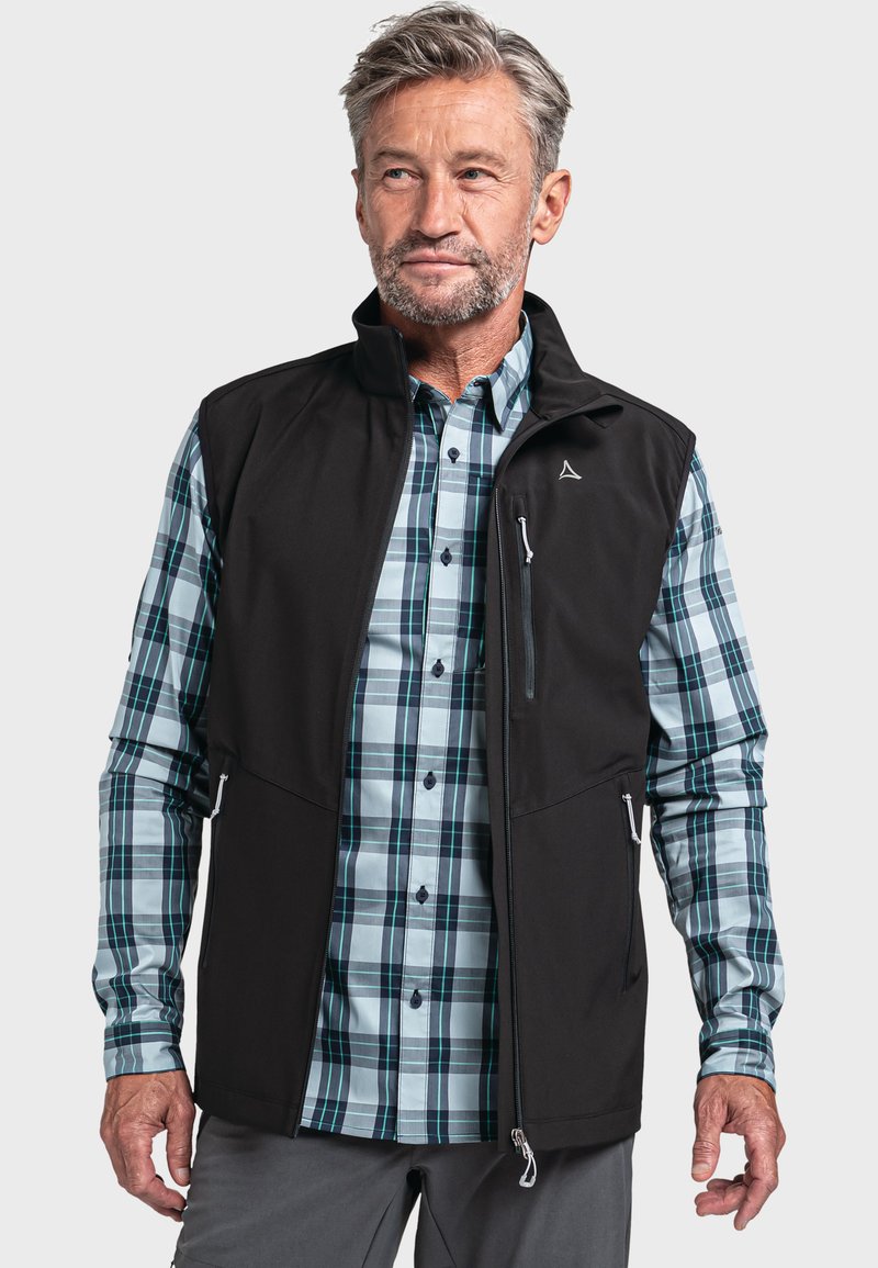 Schwarze Softshell-Weste über einem blauen und grünen karierter Hemd. Die Weste hat Reißverschlusstaschen und einen hohen Kragen. Button-down-Hemd mit langen Ärmeln.