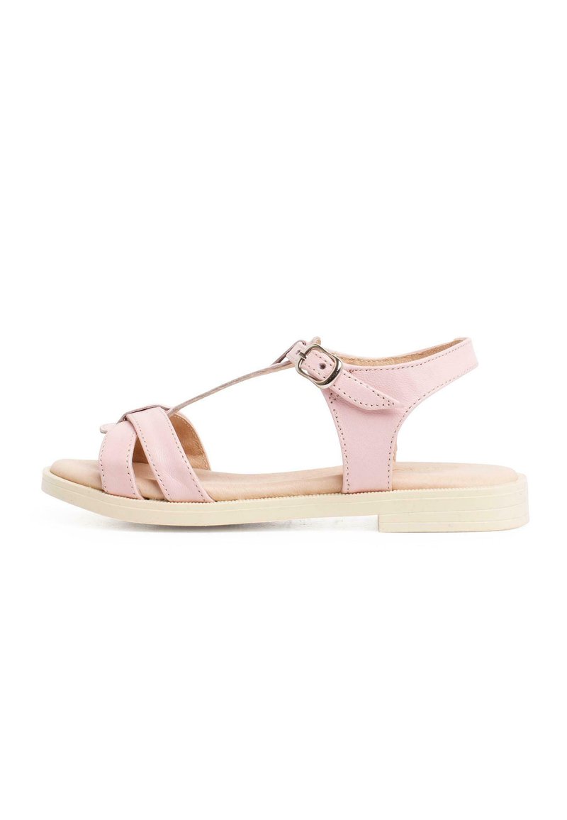 Pink leather sandal featuring crisscross straps, an ankle buckle, and a flat neutral sole, designed for comfort and style.