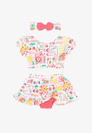 Completo estivo per bambina con stampe colorate di frutta e fiori, composto da una maglietta con maniche a sbuffo, gonna con balze e pantaloncini incorporati, e una fascia per capelli con fiocco corallo.