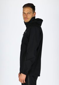 Black waterproof jacket with a hood, featuring a front zipper and elastic cuffs. Lightweight fabric, slim fit, and minimal design accents.