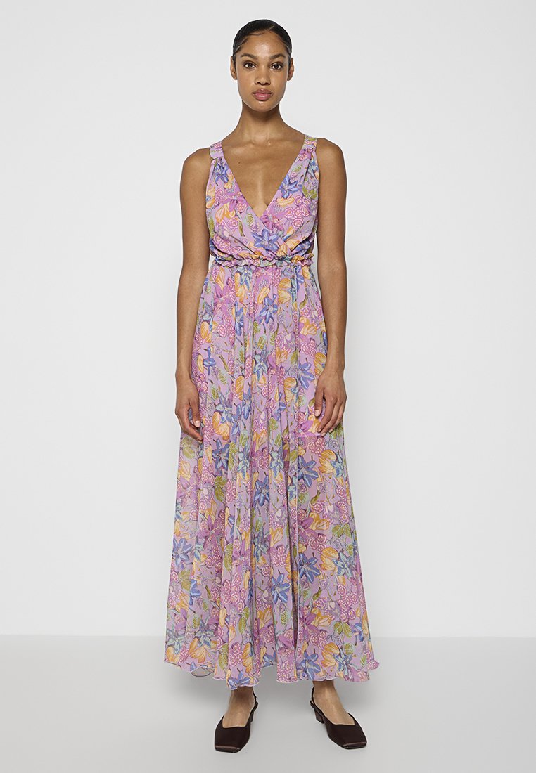 Maxi sukienka z kwiatowym wzorem w odcieniach fioletu, różu i zieleni. Bez rękawów, z dekoltem w literę V, ze zgromadzonym wąskim pasem i zwiewnym, przezroczystym materiałem.