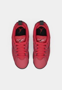 Un par de zapatillas altas rojas con cordones, texto "Flight" en las lengüetas y plantillas negras con un logotipo de silueta roja, vistas desde arriba.