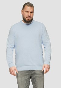 Hellblauer Pullover mit rundem Halsausschnitt, langen Ärmeln und gerippten Bündchen sowie Saum. Hergestellt aus weichem Stoff mit dezentem Logodetail auf der Brust.