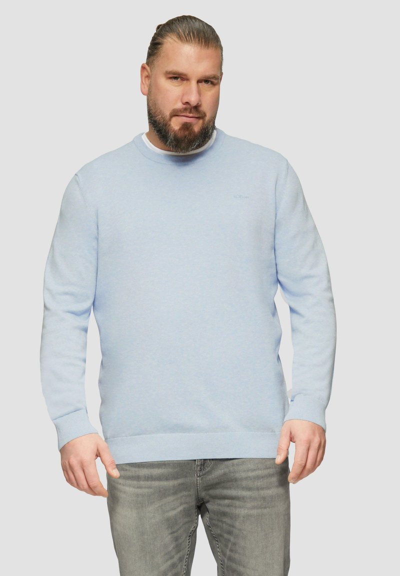 Hellblauer Pullover mit rundem Halsausschnitt, langen Ärmeln und gerippten Bündchen sowie Saum. Hergestellt aus weichem Stoff mit dezentem Logodetail auf der Brust.