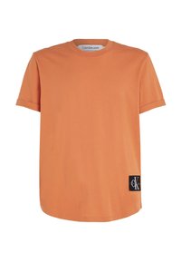 Orange bomulls-t-shirt med rund hals, korta ärmar och en svart logotyp-lapp på sidan. Slät textur och avslappnad passform.