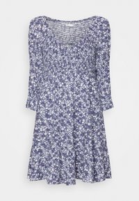 Vestido floral morado con una parte superior fruncida, mangas largas y falda acampanada. El material parece ligero, con una textura suave y pequeñas flores blancas.