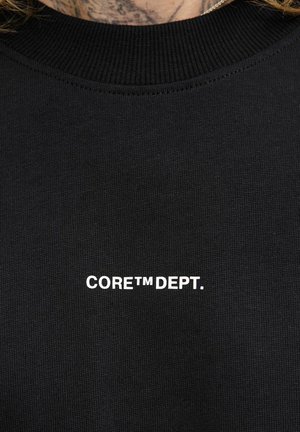Black sweatshirt with ribbed neckline, featuring "CORE™ DEPT." logo in white text on the front. Made from textured fabric.