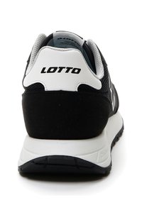 Scarpa sportiva nera con una parte superiore in suede e mesh, dettagli bianchi e logo sul tallone, dotata di una suola bianca imbottita e battistrada testurizzato.