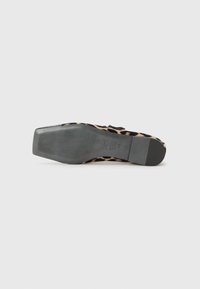 Chaussure plate en imprimé léopard avec une semelle en caoutchouc noir et un fond texturé. Présente un matériau supérieur lisse et une forme élancée.