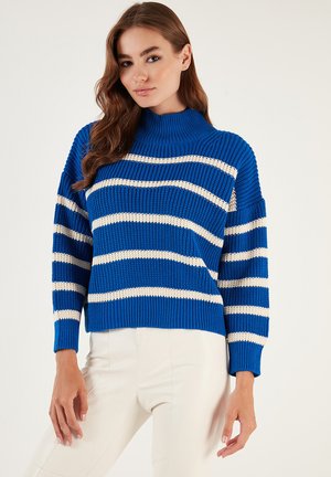 Maglione a maglia a righe blu con collo alto, caratterizzato da strisce orizzontali color crema e una texture a coste. Fit casual con maniche lunghe.