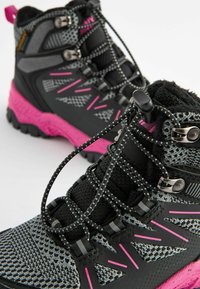 Bottes de randonnée noires et grises avec des accents roses, présentant un upper en mesh, une semelle texturée et un système de laçage intégré. Les détails de conception notables incluent des éléments en métal argenté.