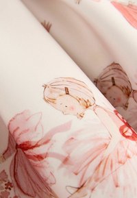 Blødt hvidt stof med sarte lyserøde og røde skitser af børn, der holder hinanden i hånden, med blid skygge og foldet tekstur.