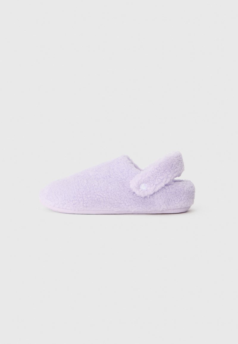 Pantufa roxa felpuda com uma textura suave, design sem atrás e correia ajustável com detalhe em botão. Sola plana para uso interior.