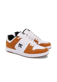 White and tan sneakers with a suede and synthetic upper, featuring a lace-up design, padded collar, and a logo on the side. Rubber sole.
