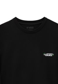 T-shirt nera a maniche corte realizzata in cotone, con il logo "VANS" bianco e dettagli verdi nella zona sinistra del petto. Design a vestibilità classica.