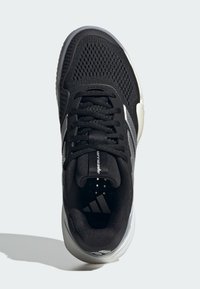 Μαύρο αθλητικό παπούτσι με ανώτερο μέρος από δίχτυ, κλείσιμο με κορδόνια και ασημί λεπτομέρειες. Διαθέτει μαλακή σόλα και υφασμένες περιοχές για καλύτερη πρόσφυση.