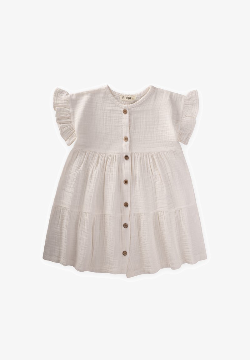 Bijela pamučna haljina s kratkim volanastim rukavima, kopčanjem sprijeda na dugmad i višeslojnim suknjom. Sadrži drvene dugmadi i mekani, teksturirani materijal.