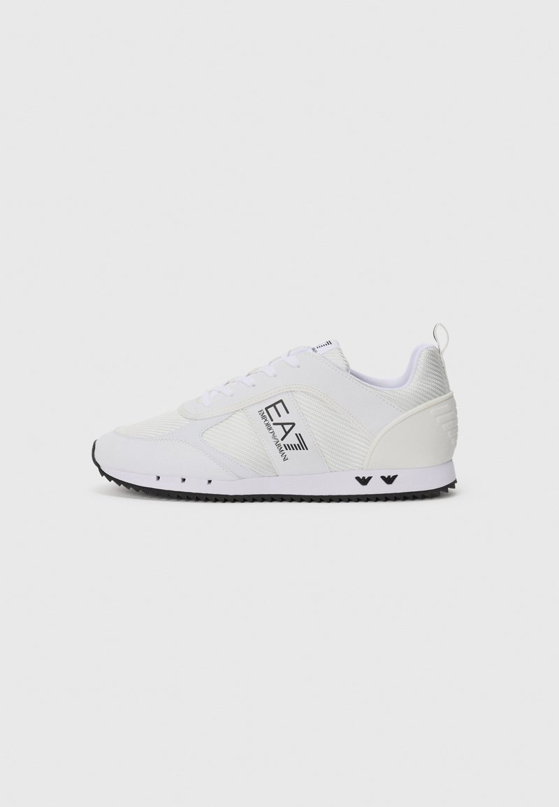 Witte sportschoenen met een bovenwerk van mesh, zwarte buitenzool en contrasterend zwart logo. Bevat een textuurdesign en een lus aan de hiel.