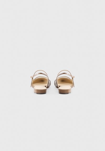 Ruskeat nahkasandaalit, joissa on matala korko, säädettävä nilkkaremmi ja avoin kärkisuunnittelu. Sileä pinta ja minimalistiset yksityiskohdat.