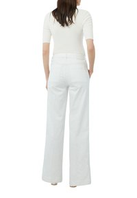 Helle, weite Hosen mit hoher Taille, aus glattem, leichtem Stoff. Verfügt über Front- und Gesäßtaschen für Funktionalität.