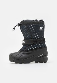 Sorte vanntette støvler med blå prikkete mønster, høy skaft, snøring på toppen, borrelåsrem og teksturert svart gummisåle for grep og støtte.