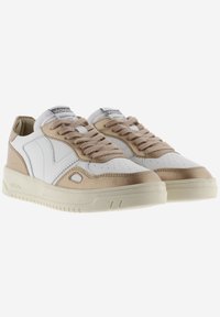 Baskets blanches et beiges avec une tige en cuir lisse, un bout perforé, des accents beiges et une semelle en caoutchouc texturée. Elles sont équipées de lacets marron clair.